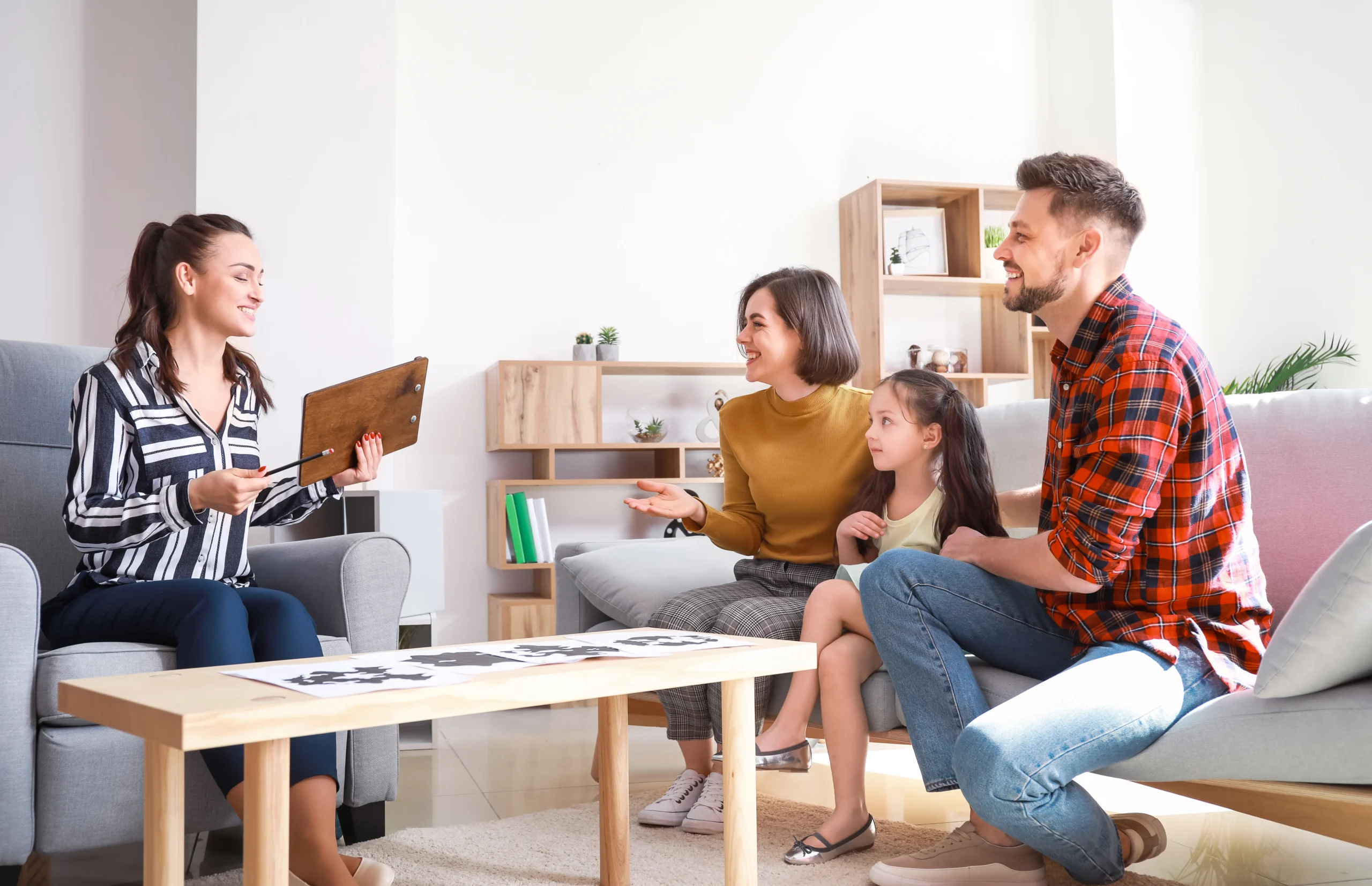 Family meeting with a therapist during a counseling session in a living-room style office.