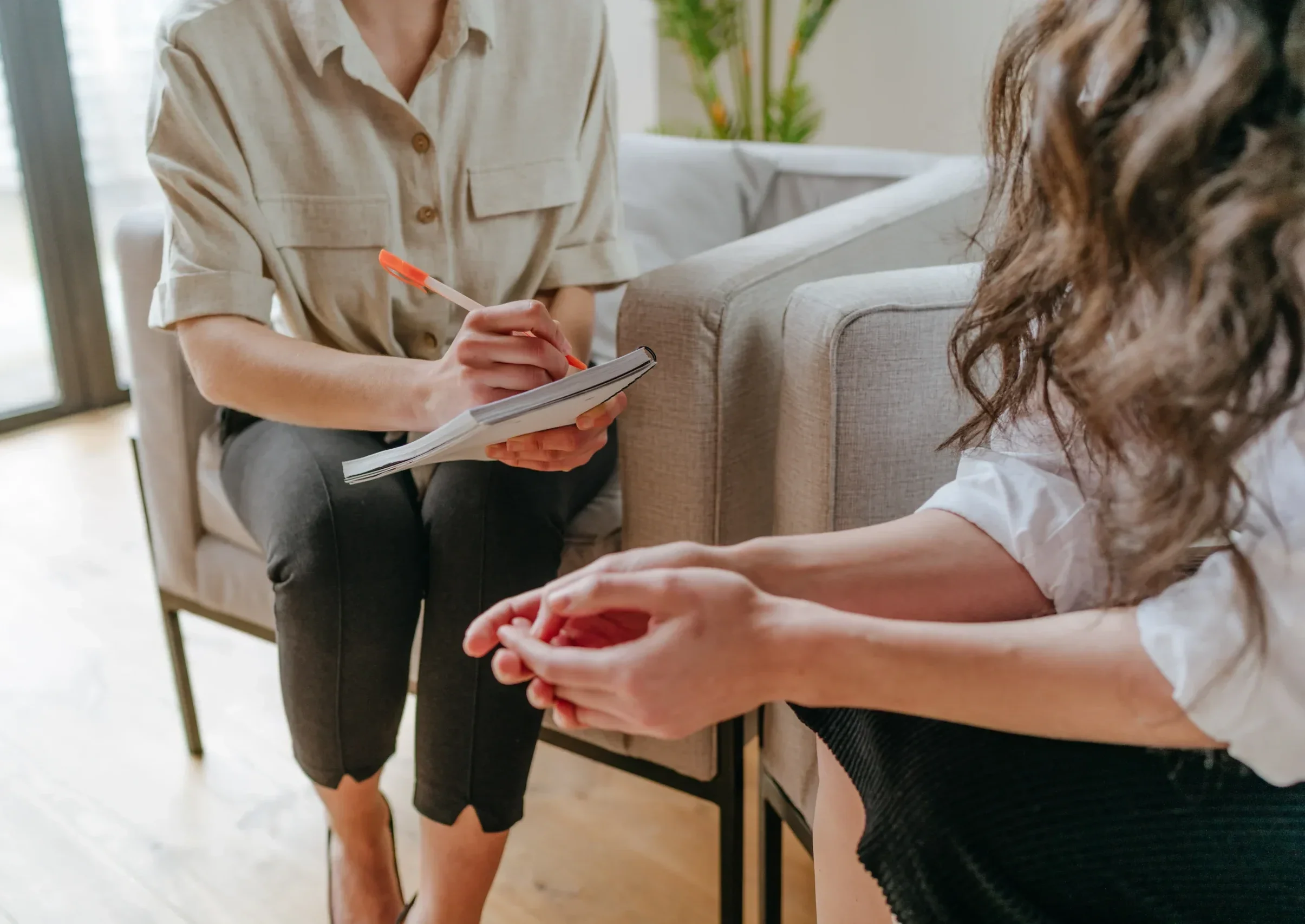 Close-up view of a therapist taking notes during a bipolar disorder counseling session.