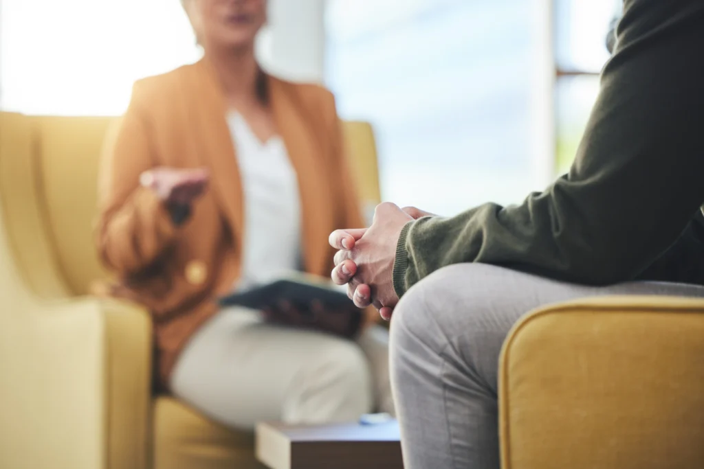 Client with hands clasped during a depression counseling session with a therapist.