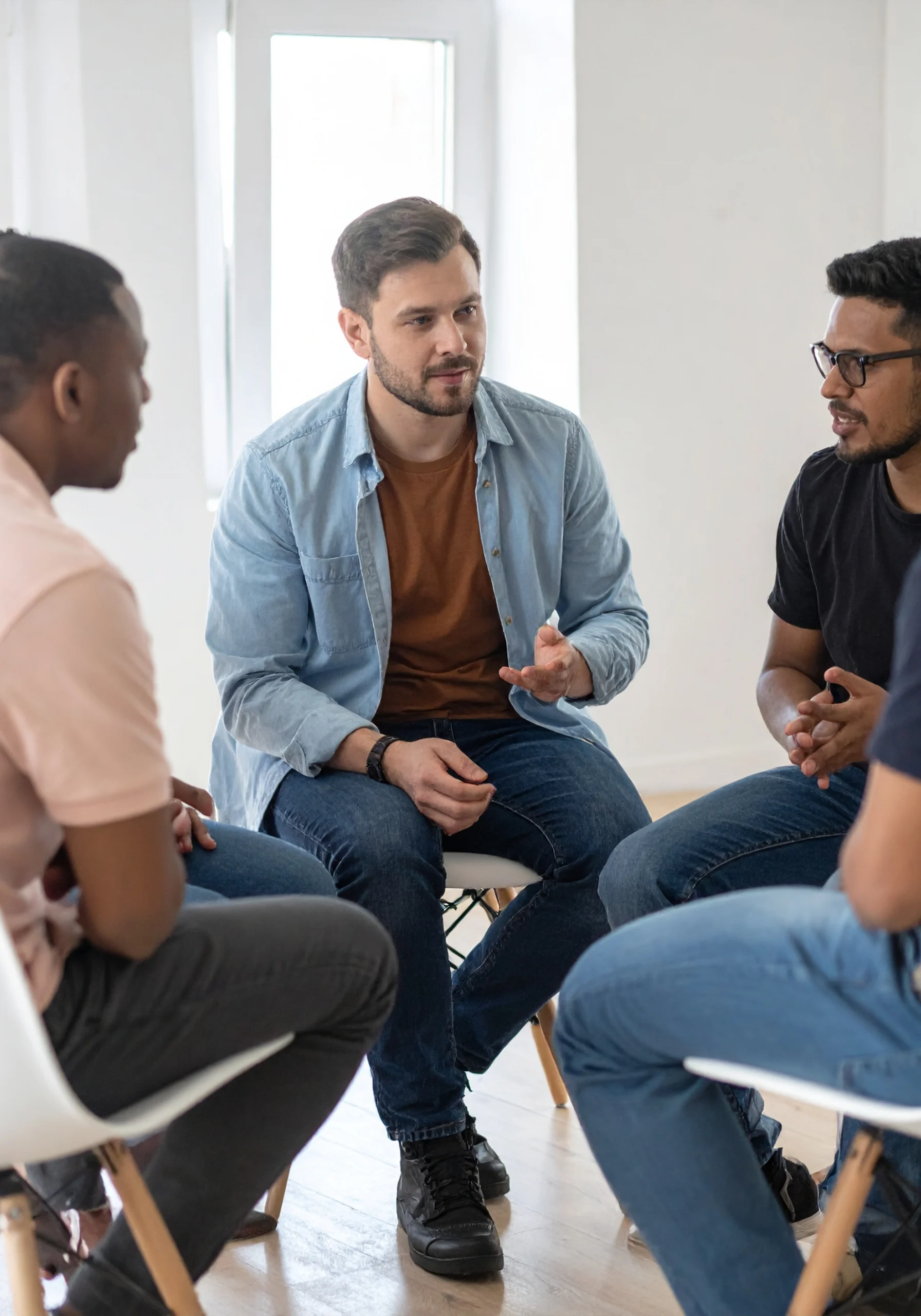 Men engaged in mental health treatment group therapy session.