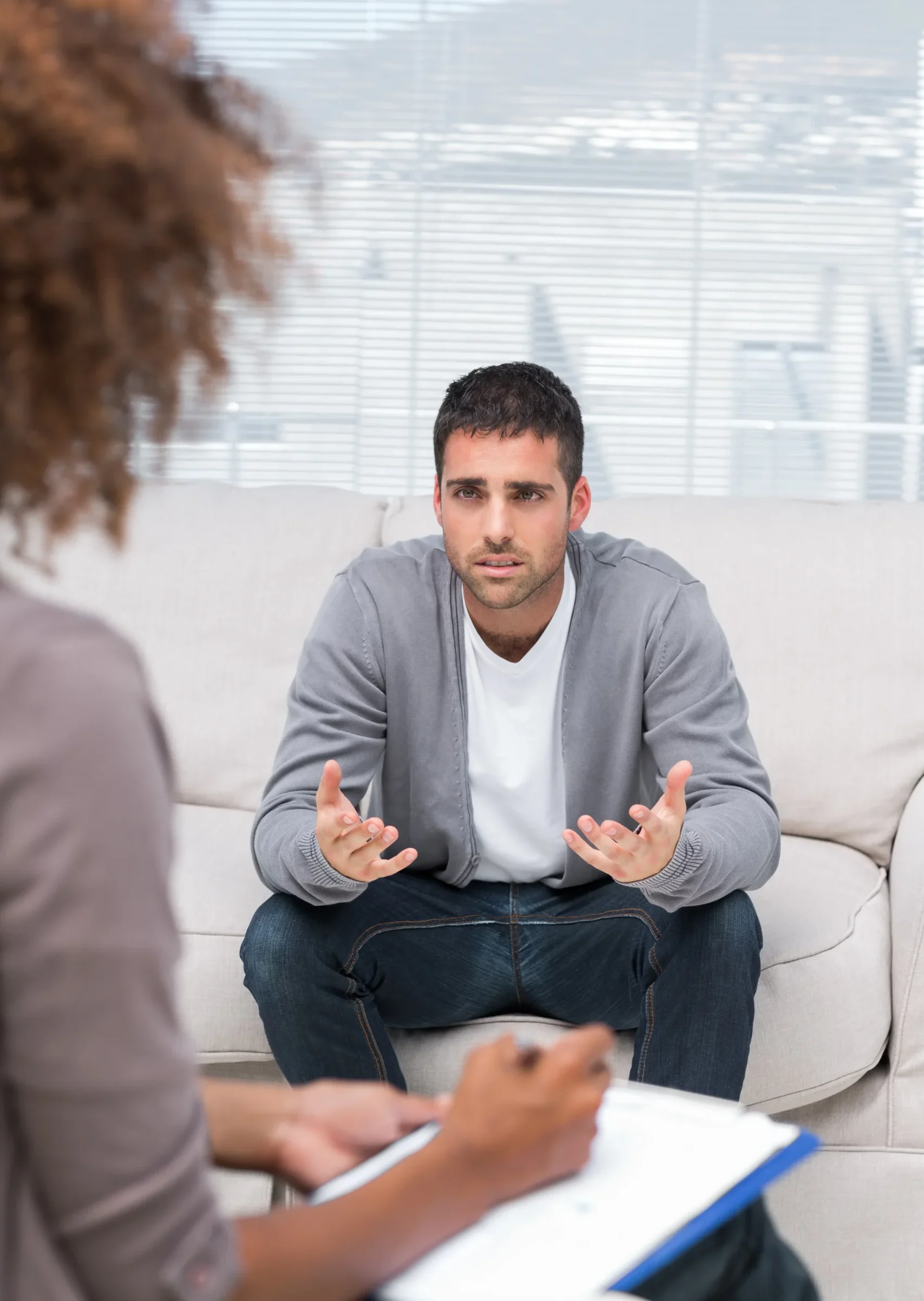 Man talking openly during an outpatient mental health therapy session.