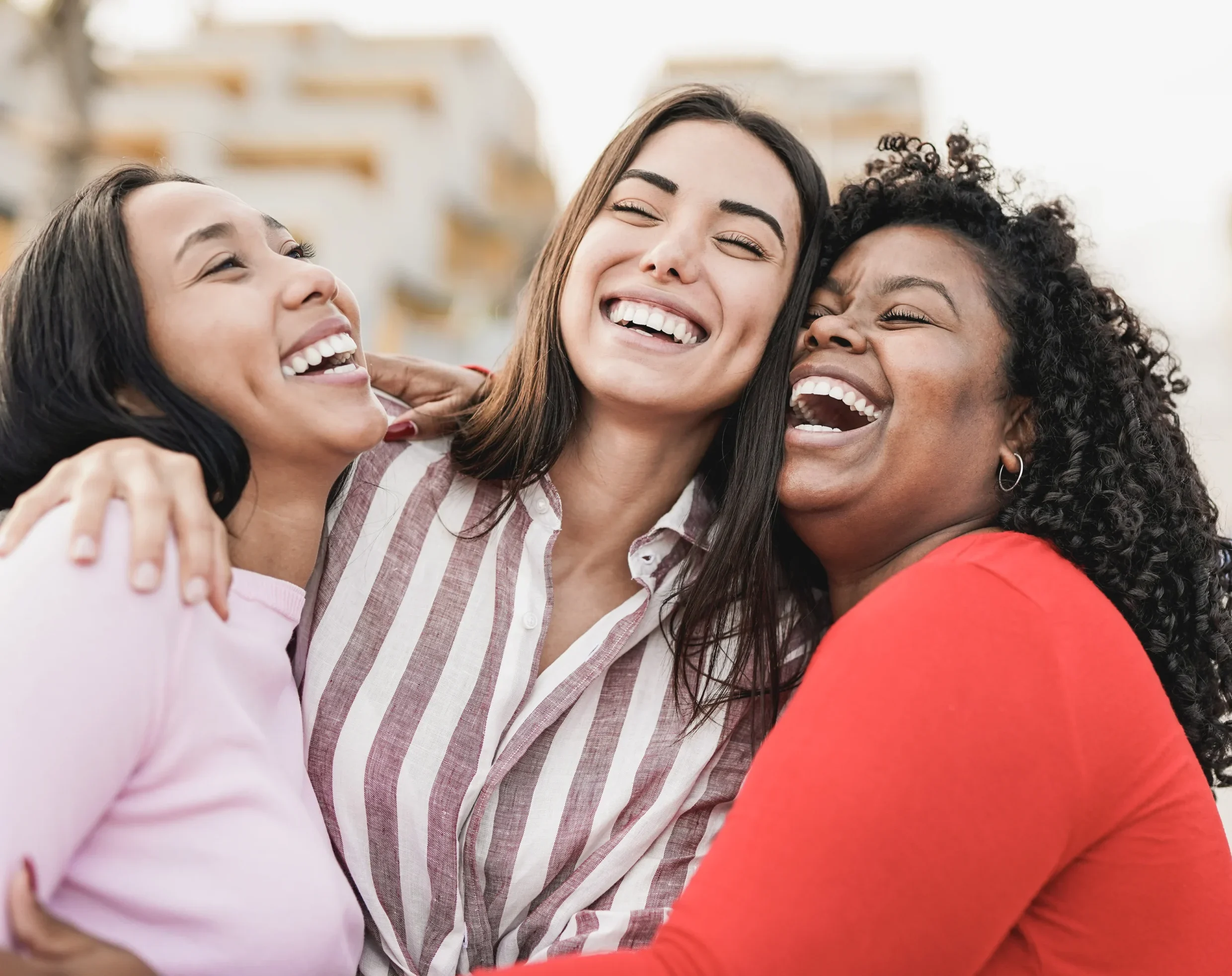 Group of young laughing women outdoors.