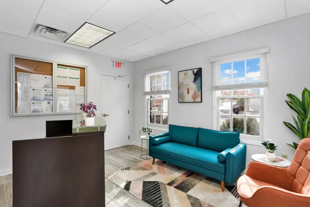 Cozy welcome area with a couch and lounge chairs at Wellness Hills.