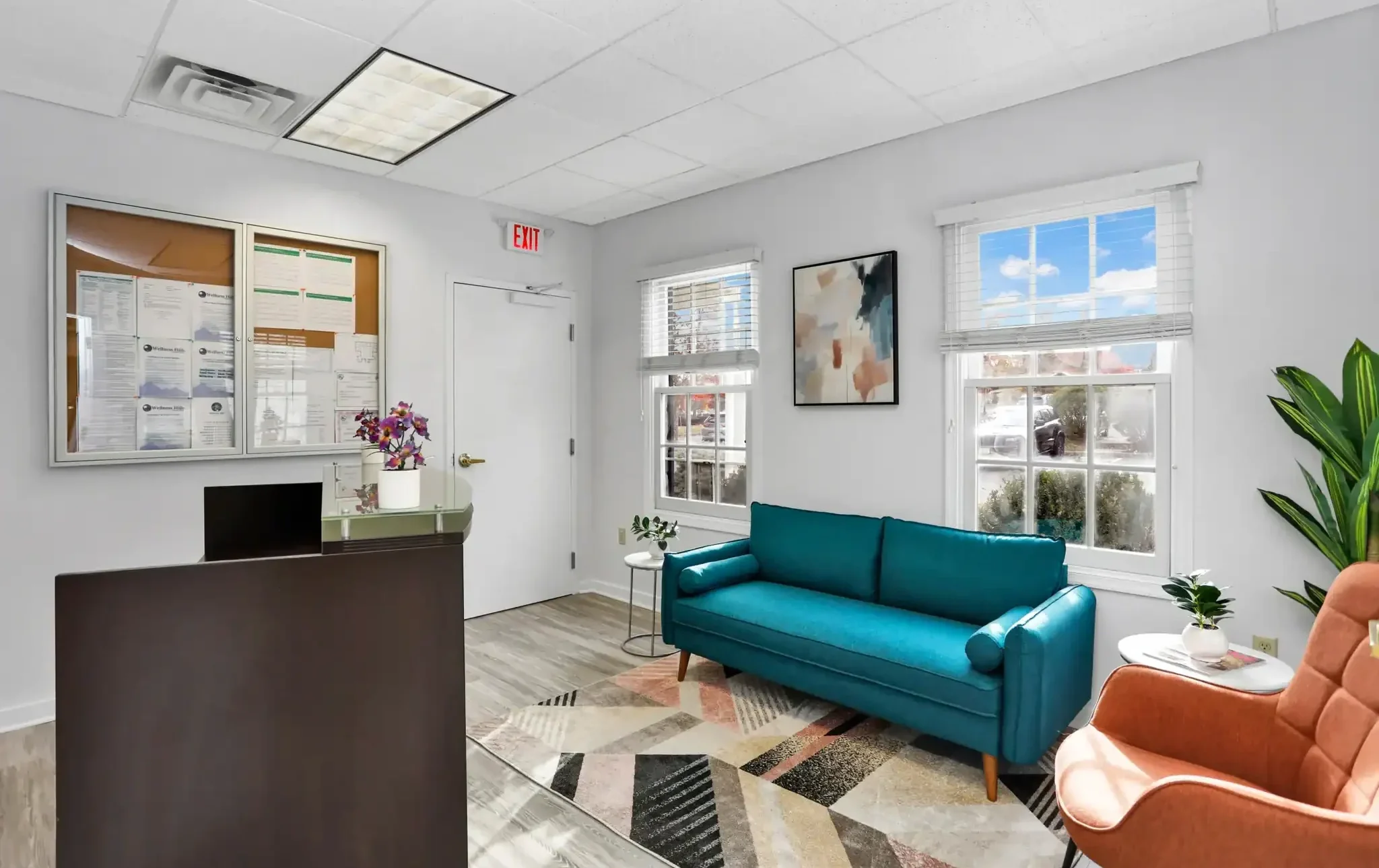 Cozy welcome area with a couch and lounge chairs at Wellness Hills.