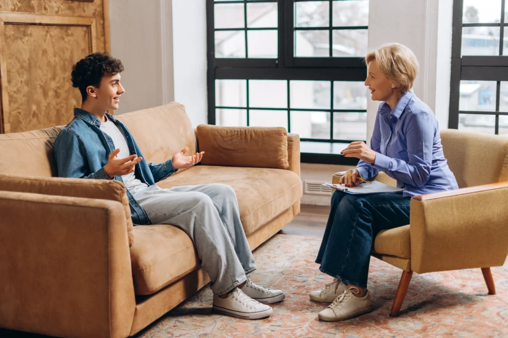Young man talking with a female therapist during a mental health counseling session.