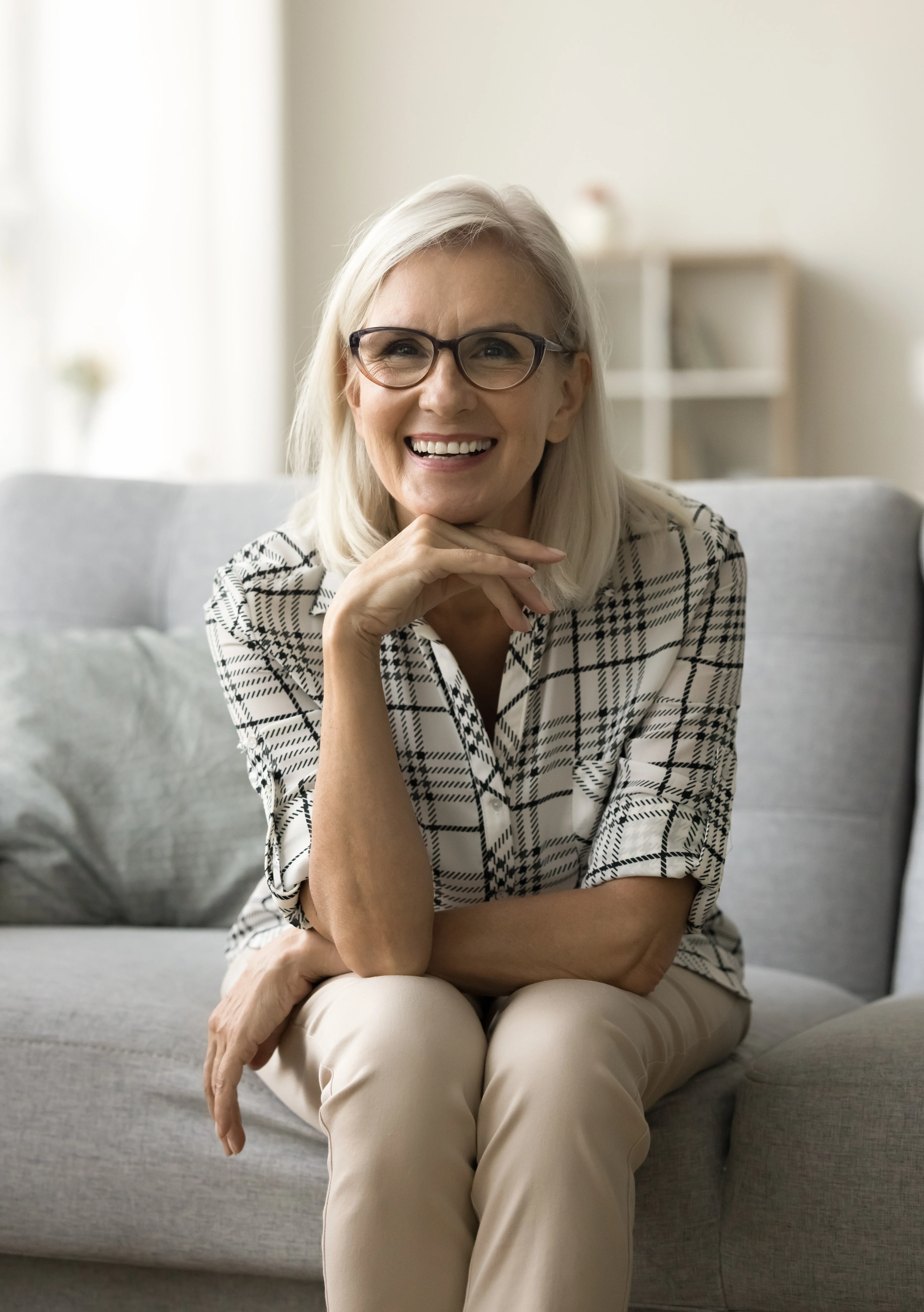 Smiling man holding a laptop in a bright modern indoor space