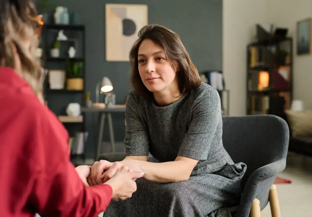 Therapist sitting with a patient during a supportive counseling session in a calm, private office setting