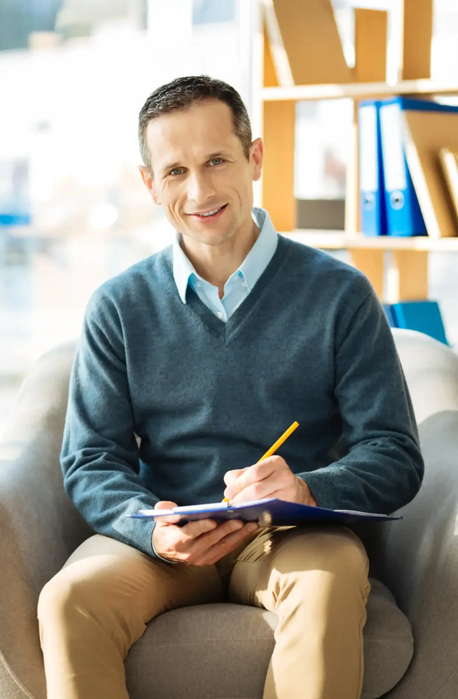 Mental health professional taking notes during a counseling session in a calm office setting