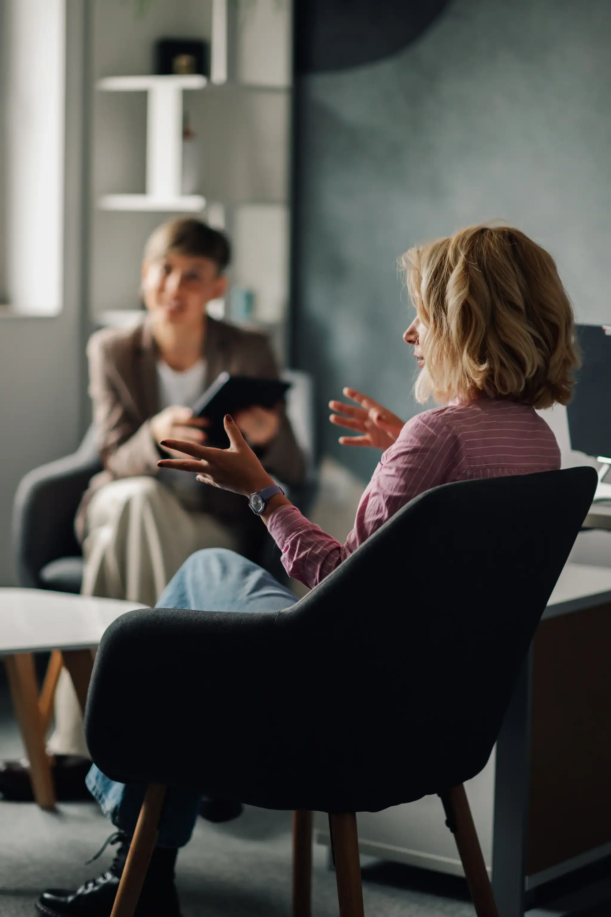 Client speaking with a therapist during an individual counseling session in an office.