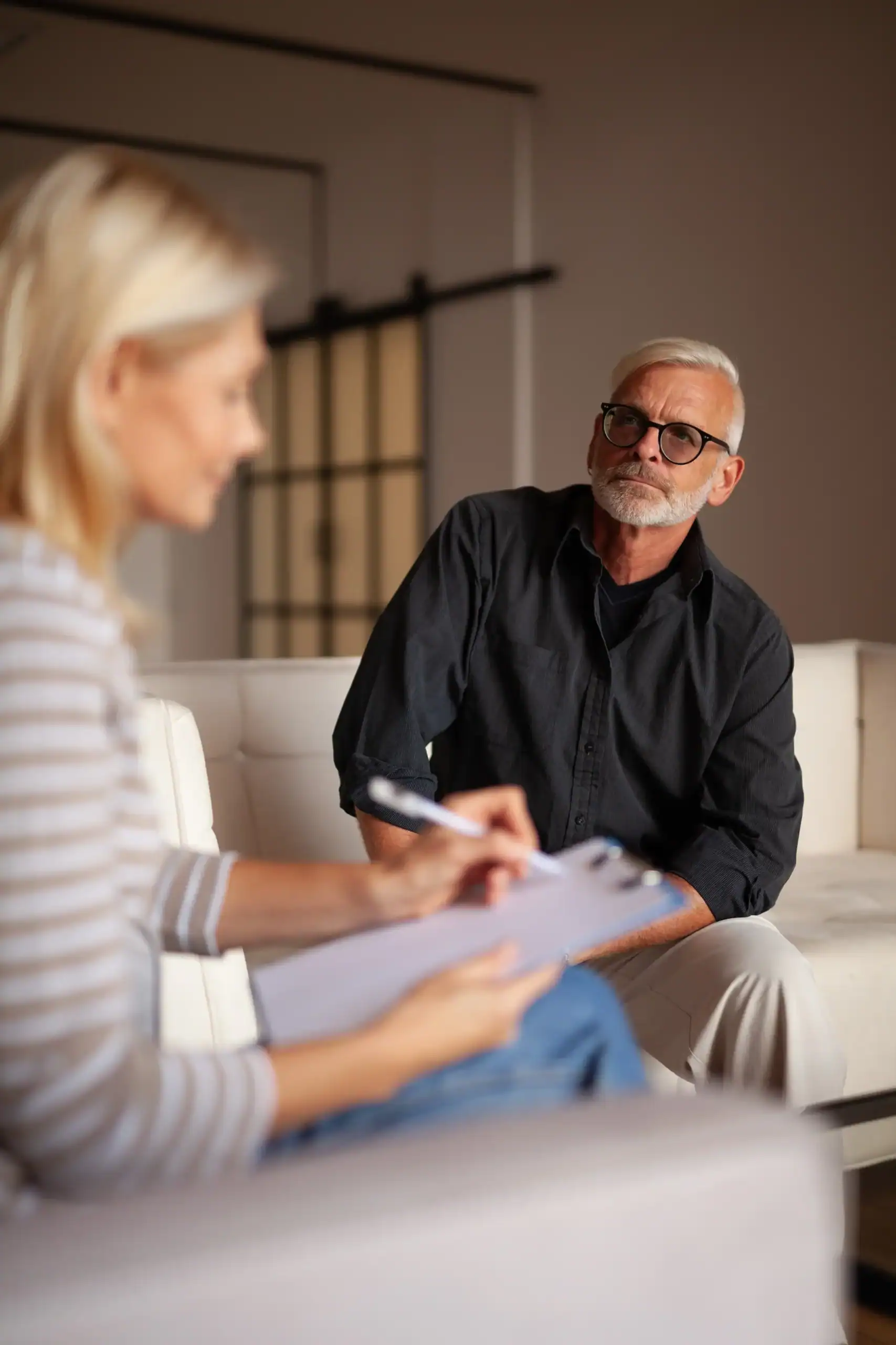 Older adult man speaking with a mental health professional during a one-on-one counseling session