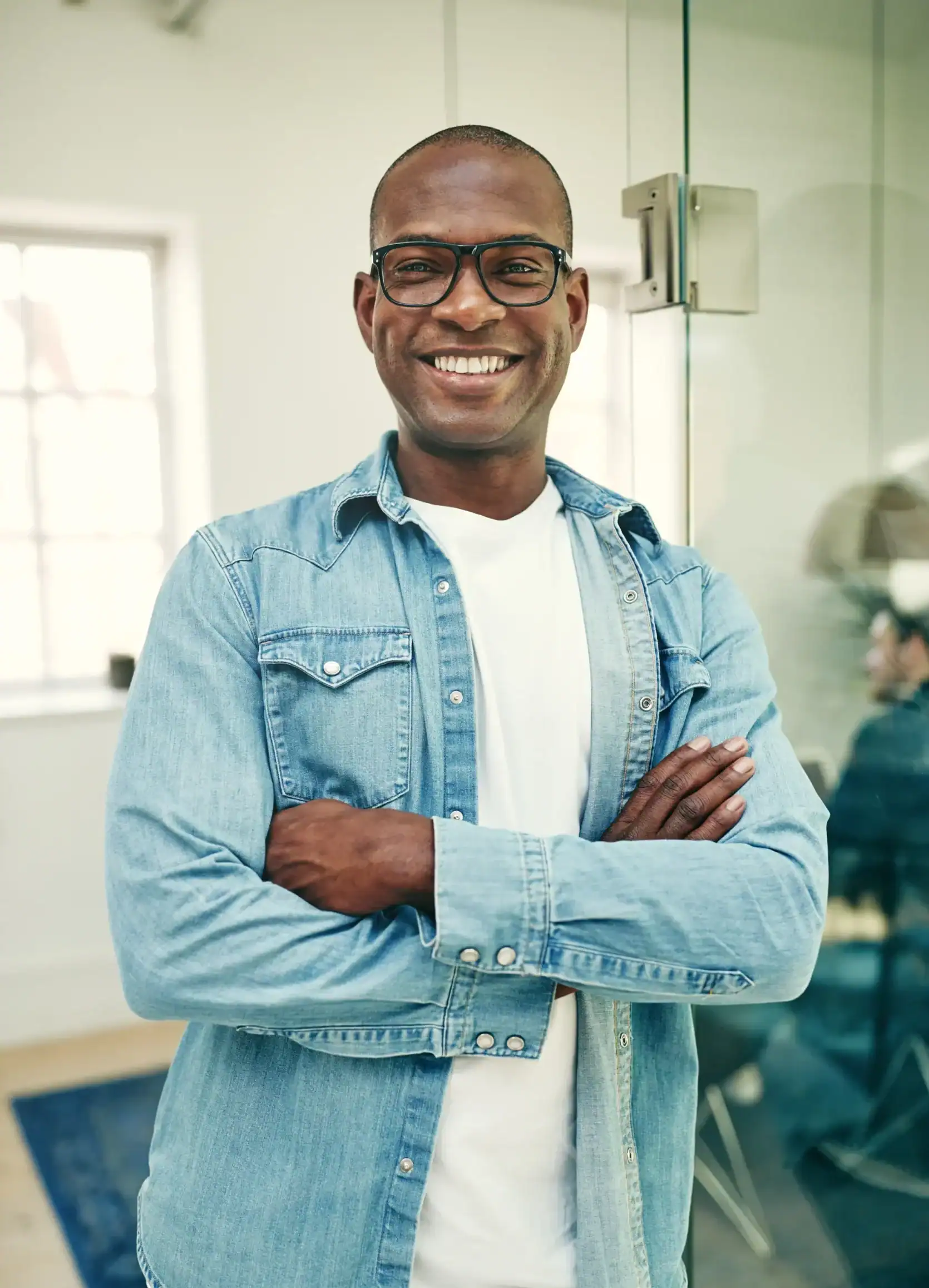 Smiling adult man standing in an office setting, representing confidence, stability, and mental well-being