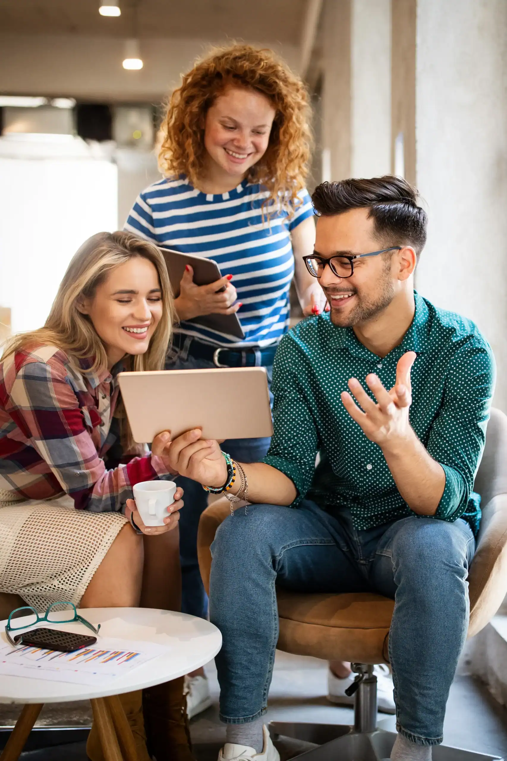 Three people looking at a tablet together and smiling