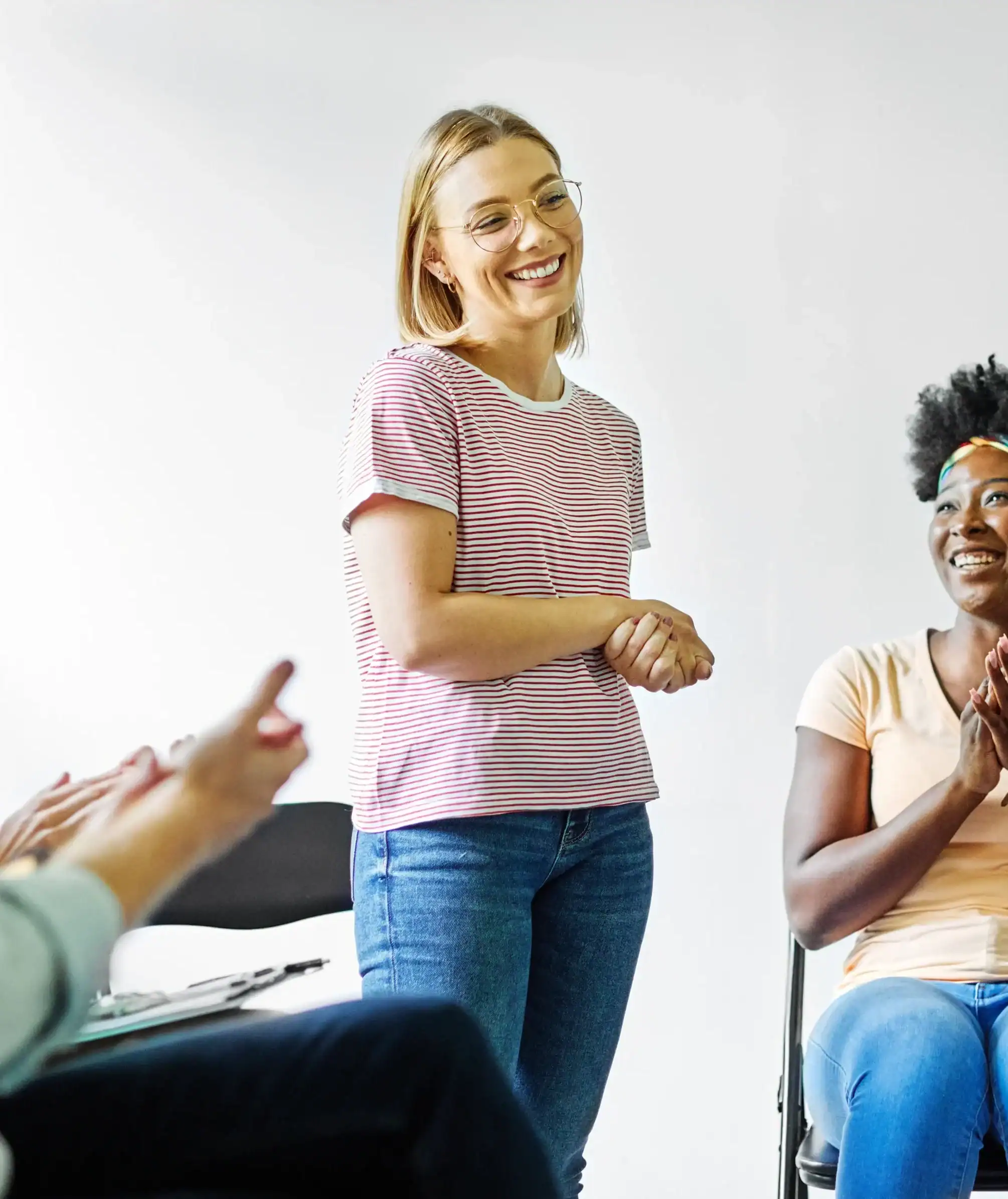 Woman speaking during a group therapy session while others listen and offer support in a collaborative setting