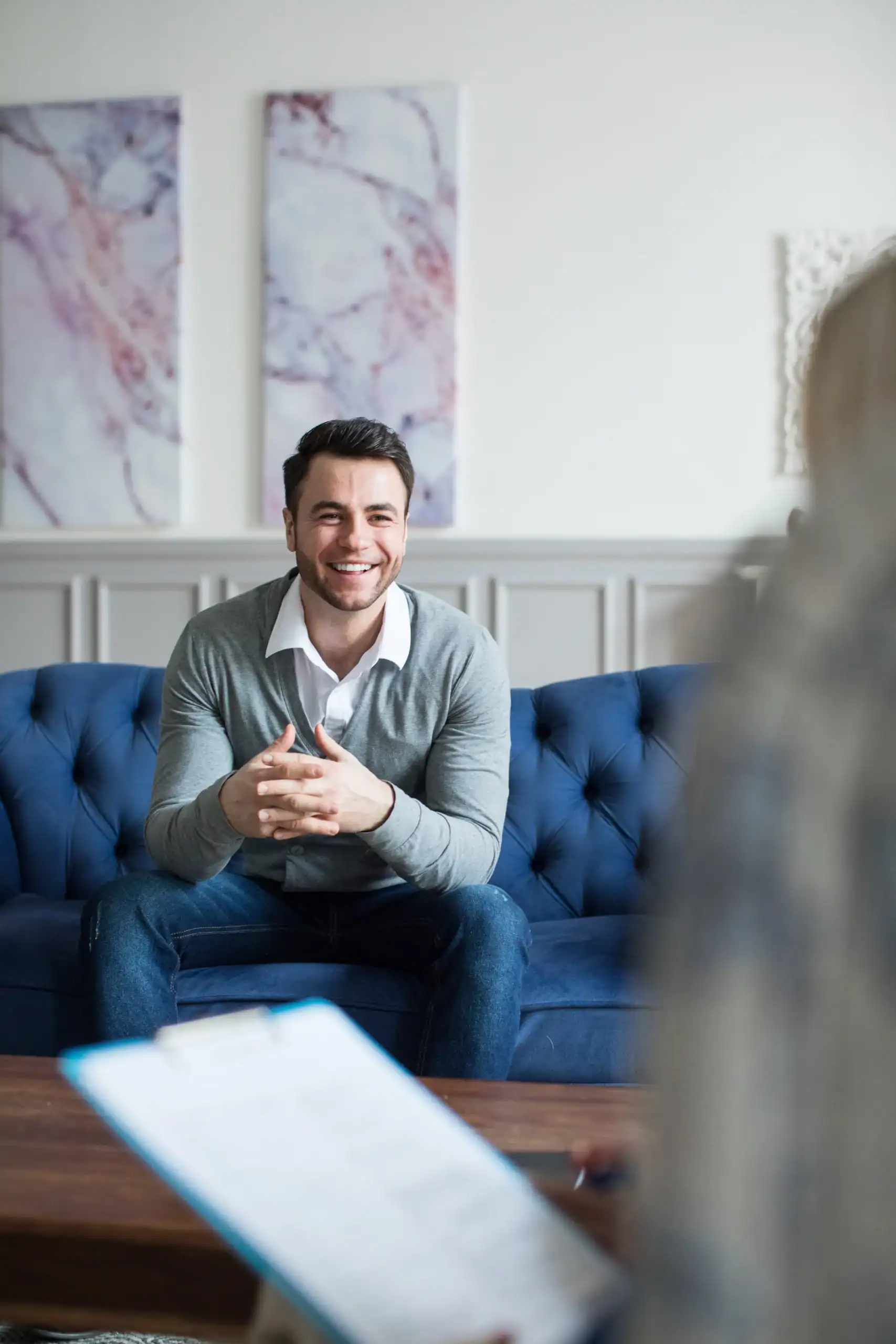 Smiling client seated on a couch during a therapy appointment