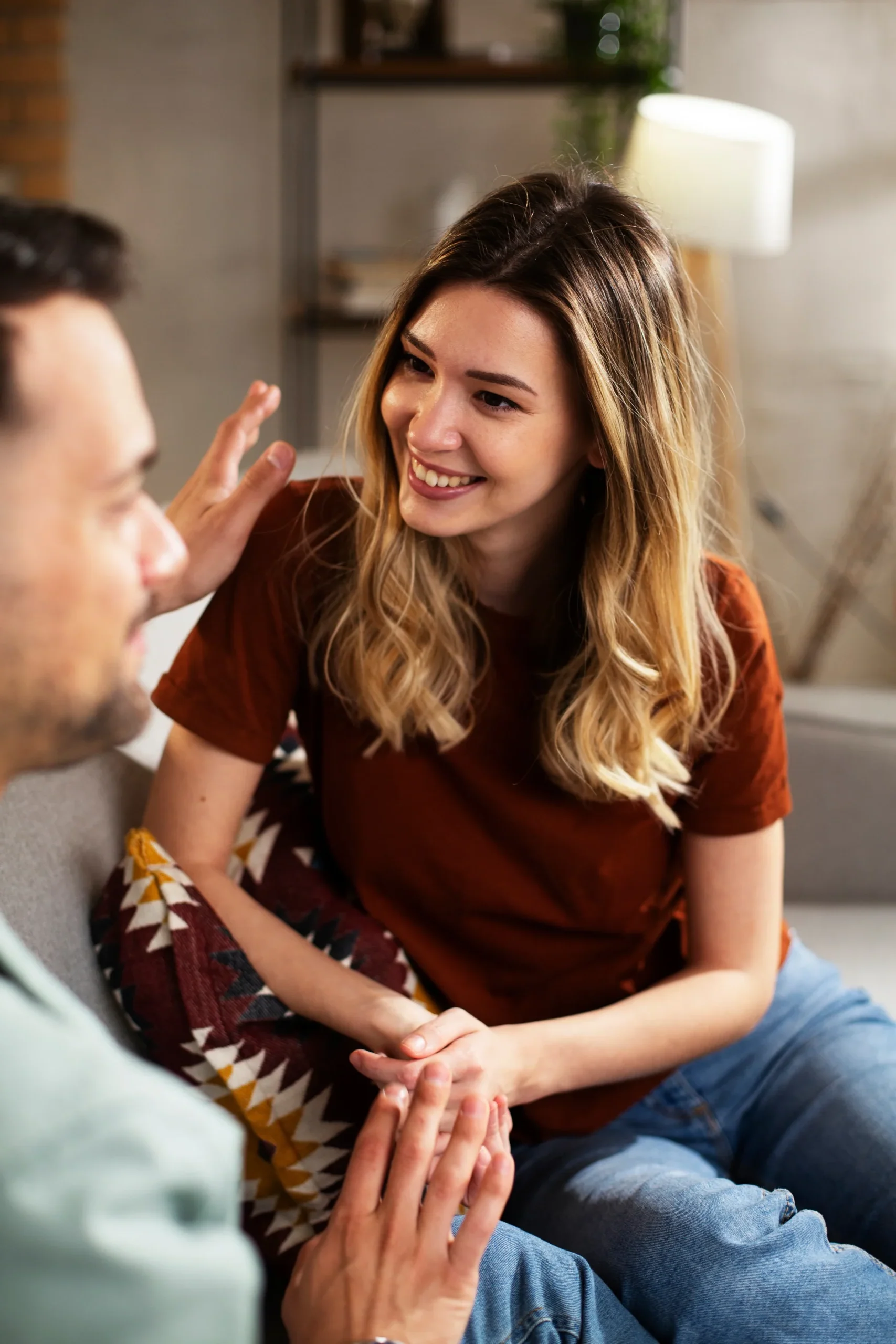 Person smiling while listening during a supportive conversation at home.