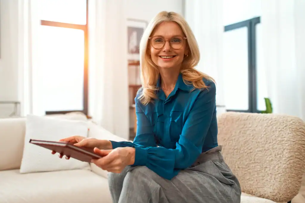 Therapist sitting in an office holding a tablet during an appointment