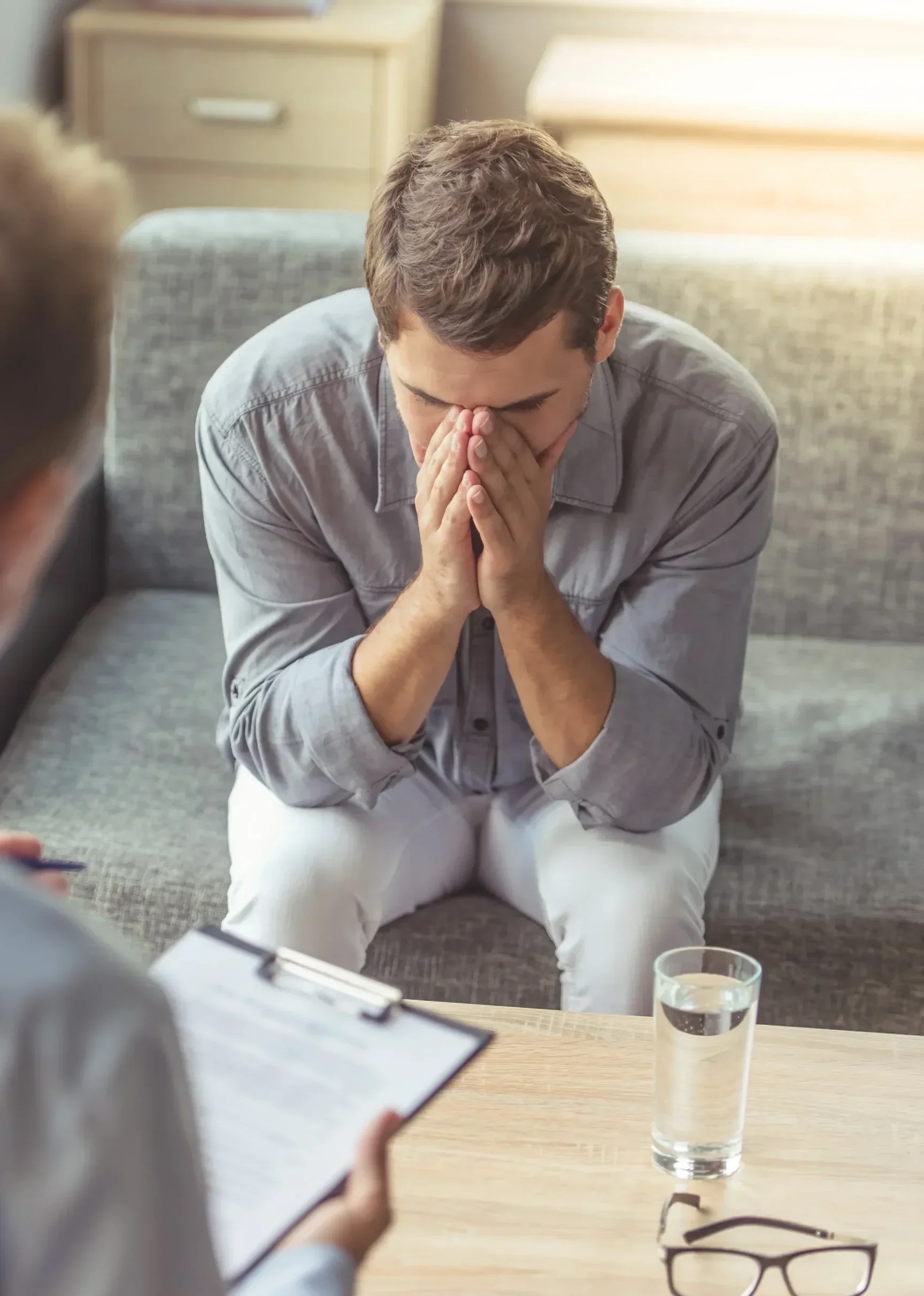 Man struggling with trauma during one-on-one mental health counseling session.