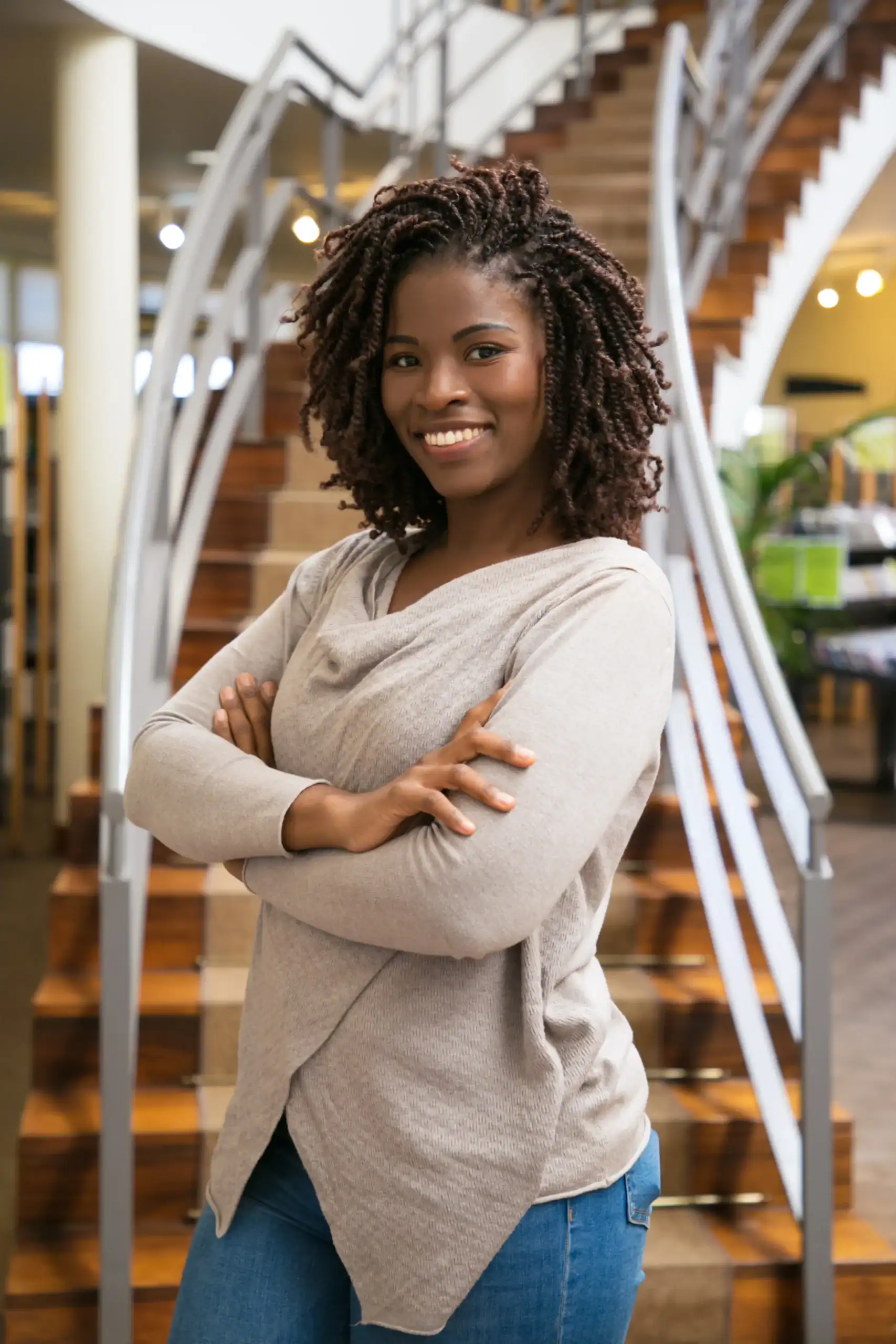 Woman smiling with arms crossed indoors