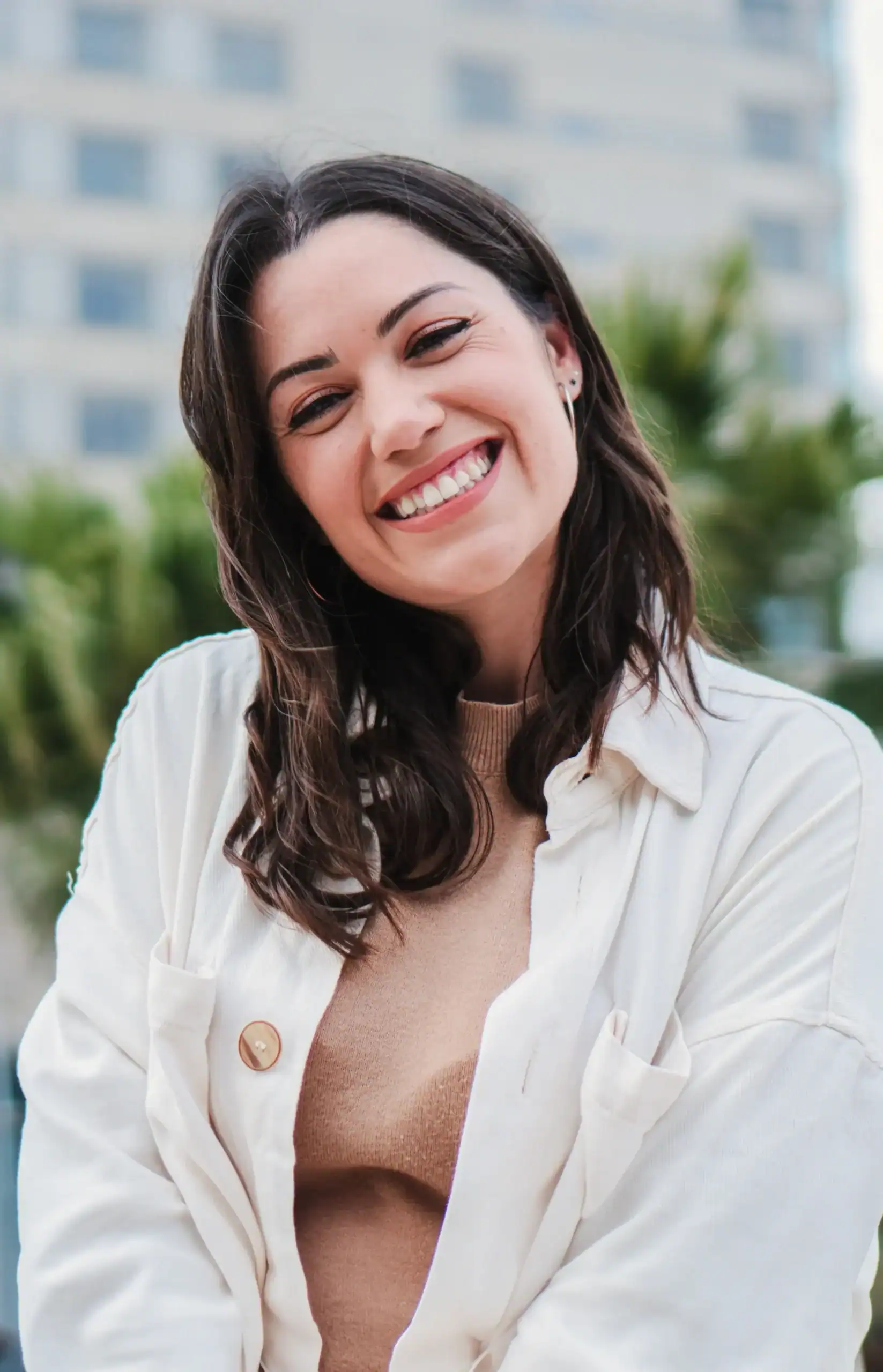 Young adult woman smiling outdoors, representing emotional well-being and mental health recovery