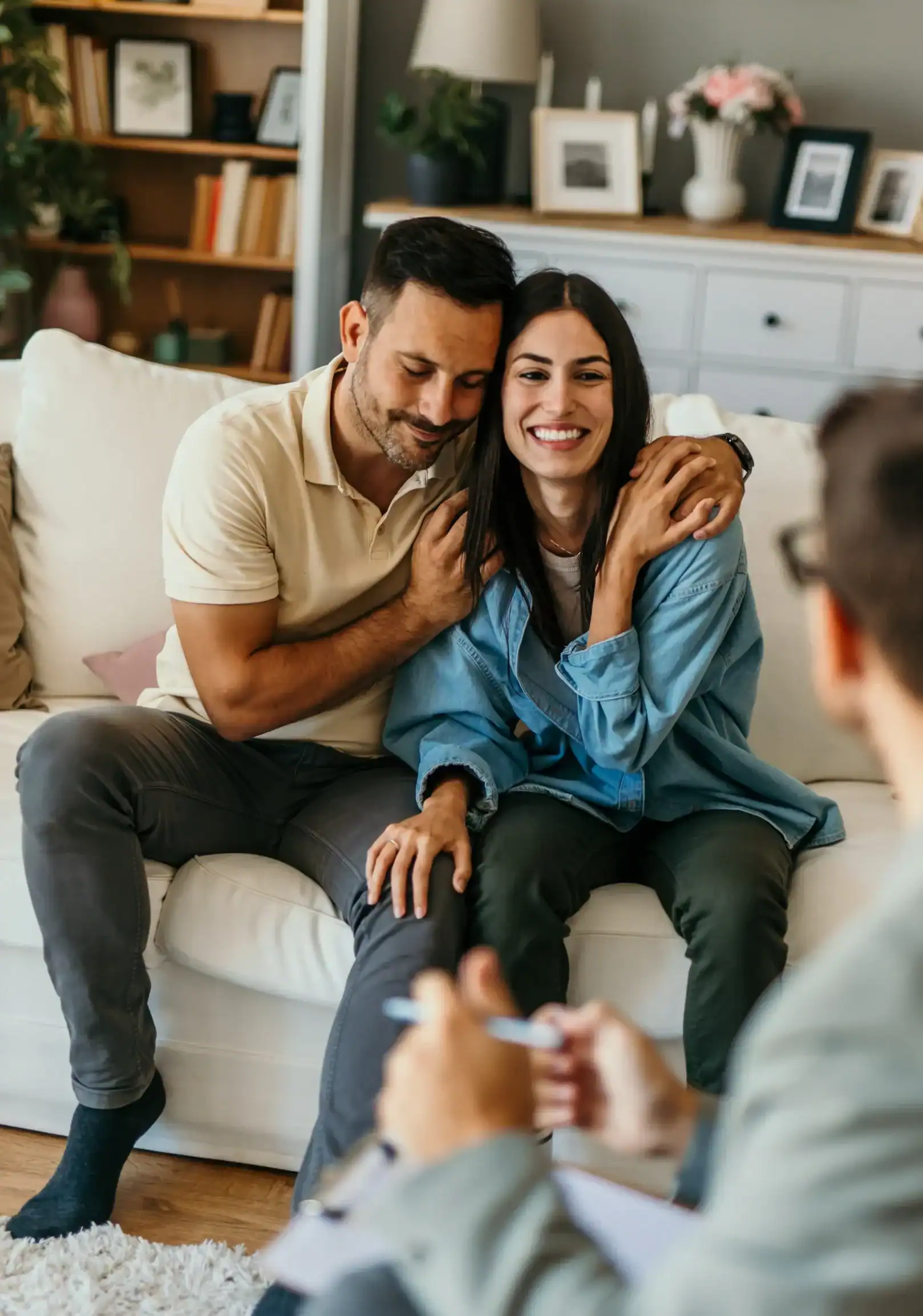Couple sitting together during a counseling session, showing emotional support and connection in a comfortable therapy setting