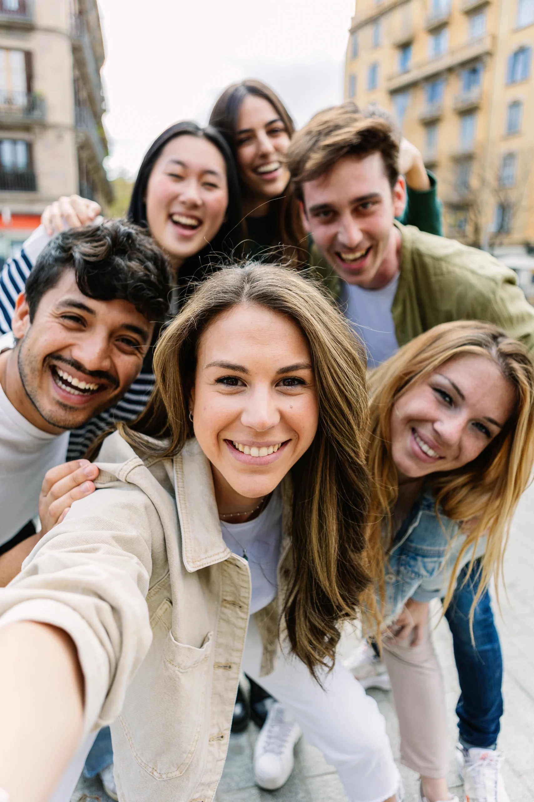 Group of young adults smiling together outdoors, representing community, connection, and peer support