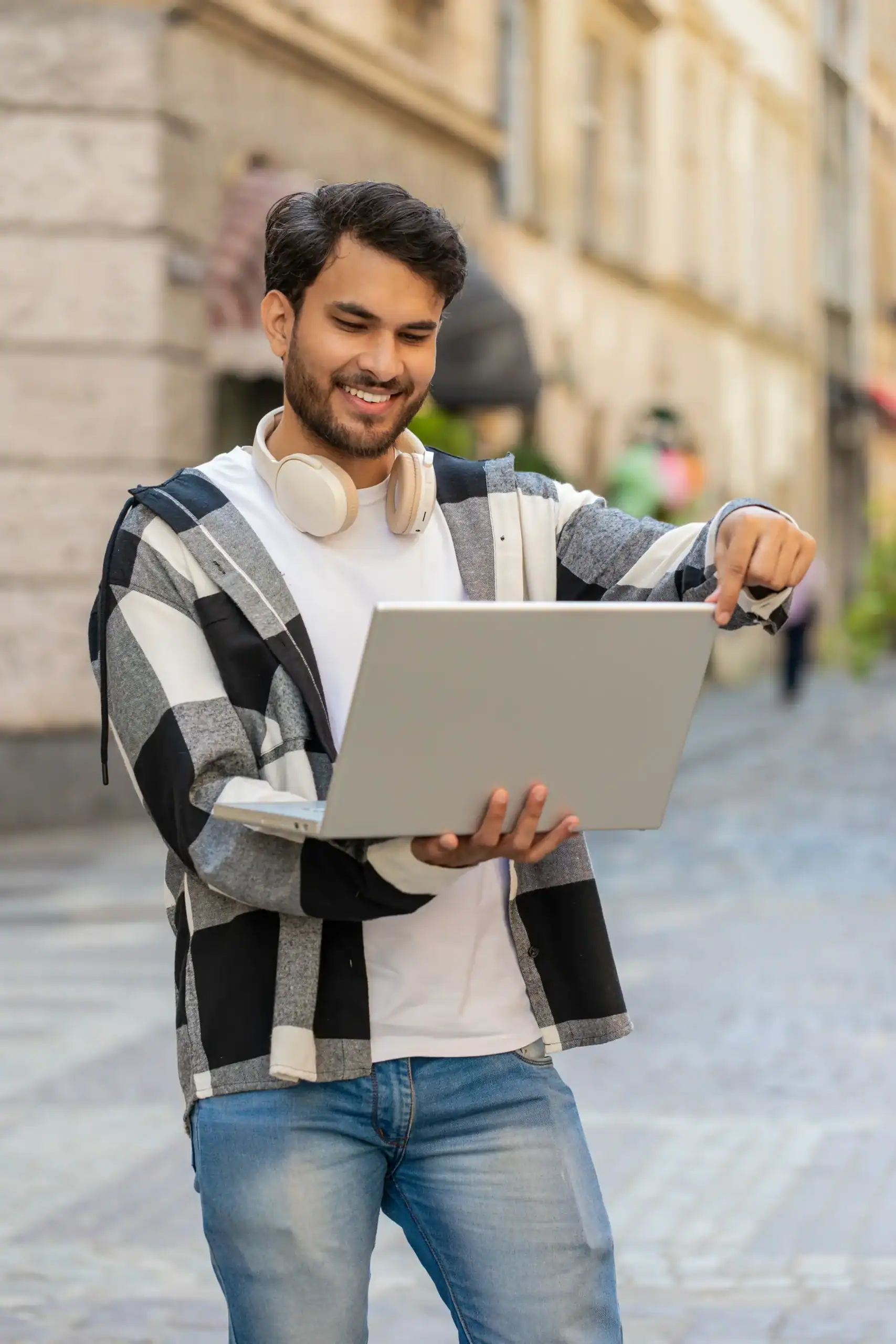 Man using a laptop outdoors to attend a telehealth appointment