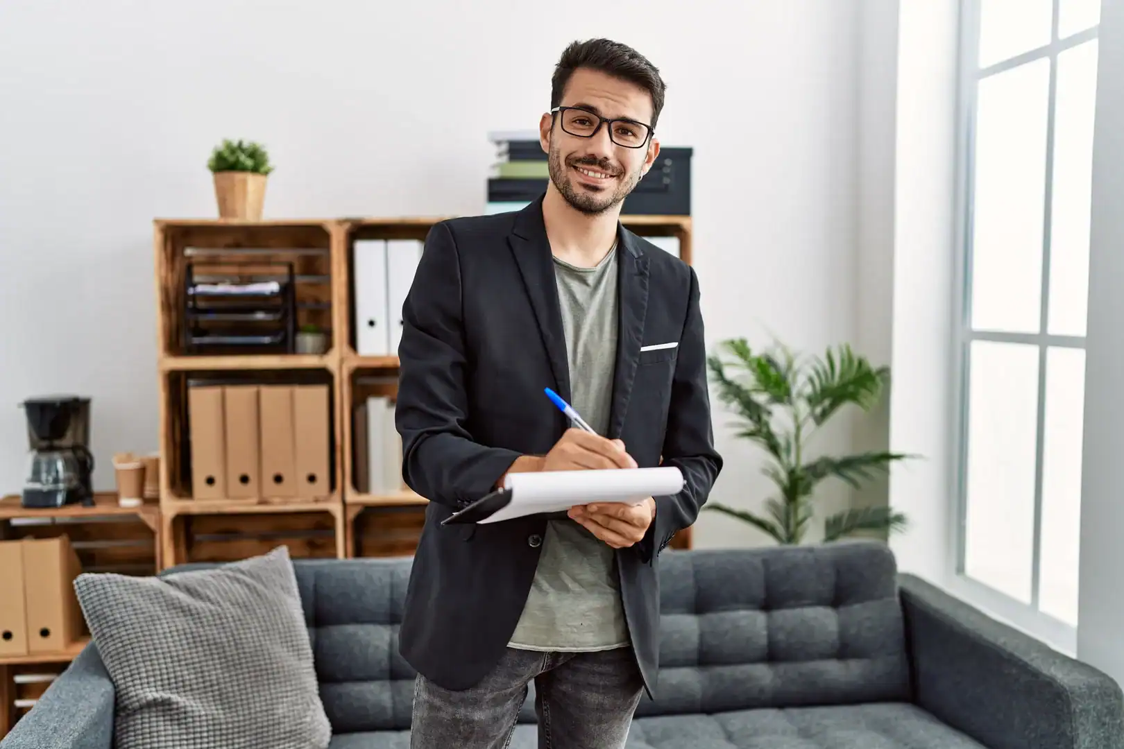 Therapist taking notes during a mental health session in an office