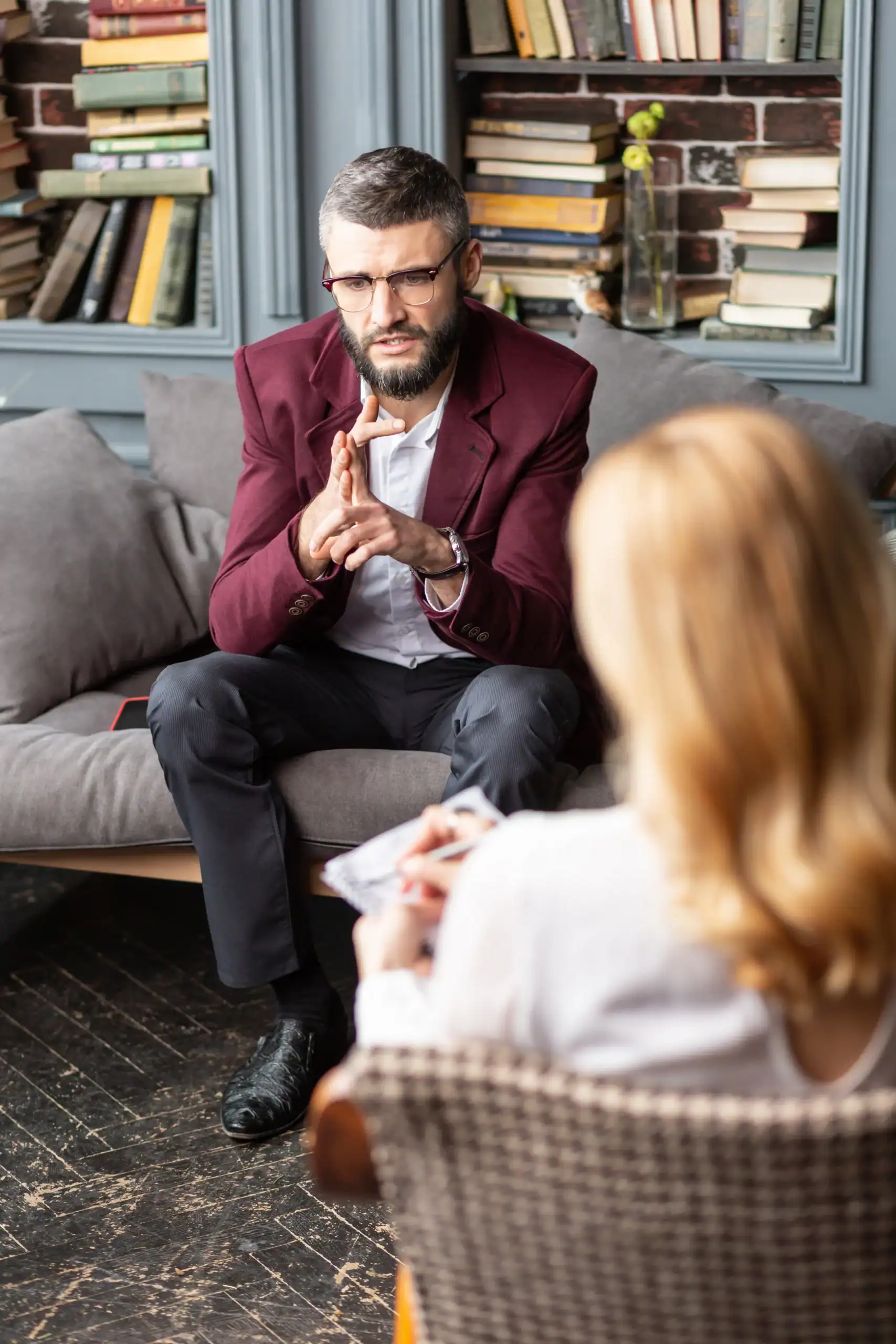 Therapist discussing treatment with a client in an office with bookshelves