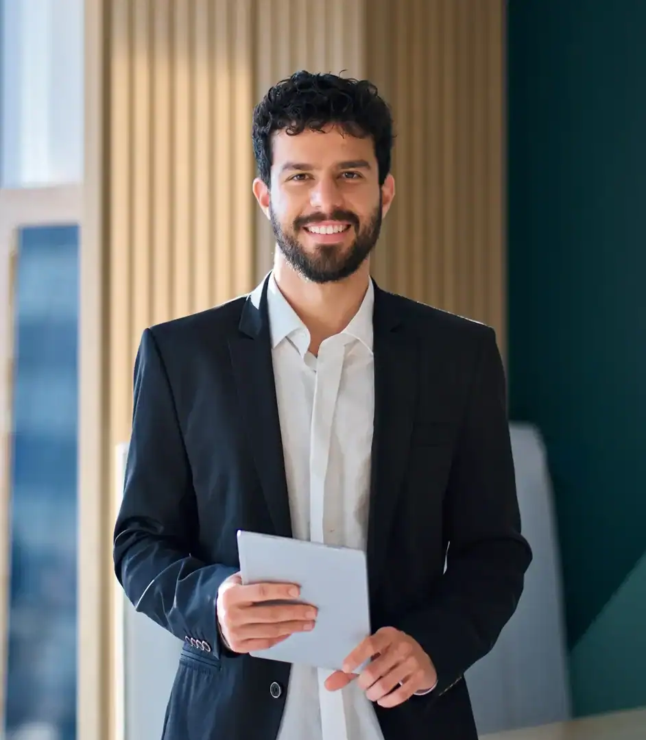 Smiling professional man in a suit holding a notebook in an office setting