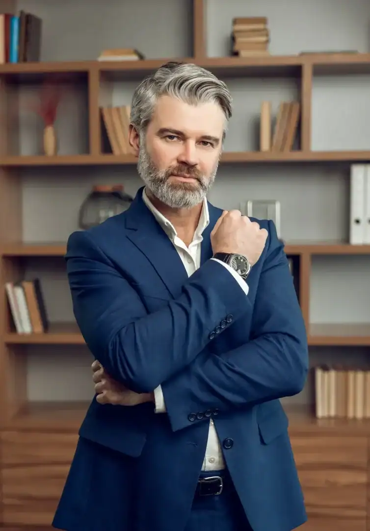 Professional man in a suit standing with arms crossed in an office