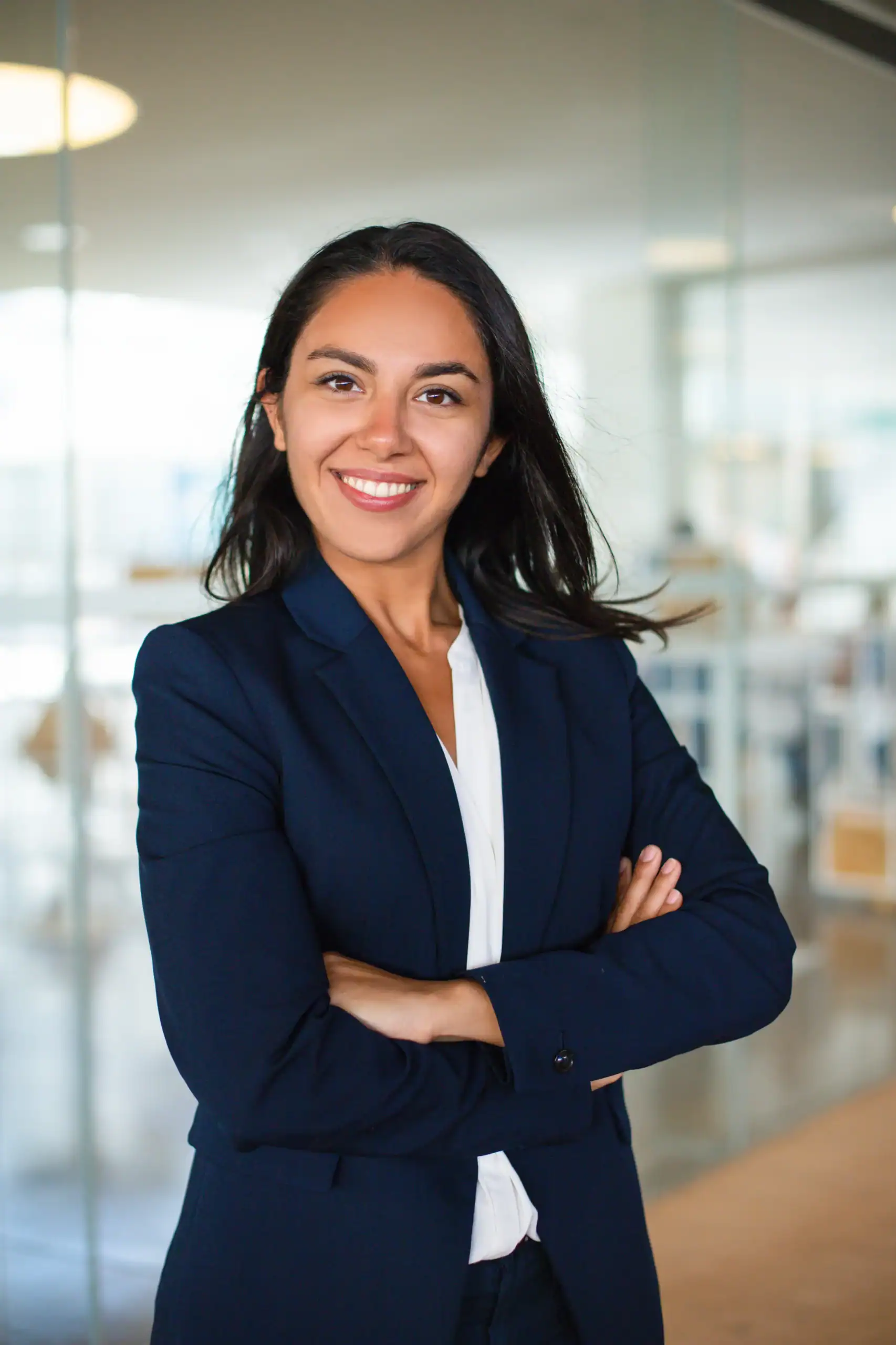 Professional woman smiling with arms crossed in a modern office