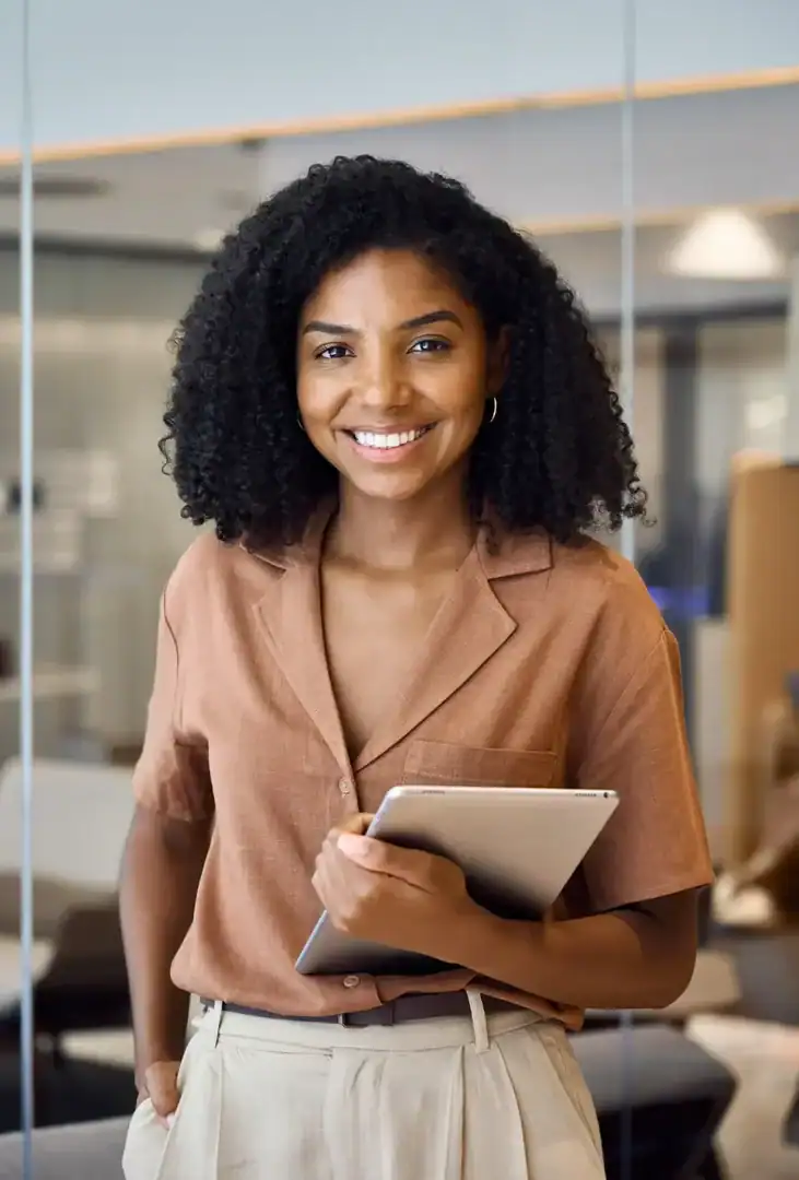 Smiling professional woman holding a tablet in an office