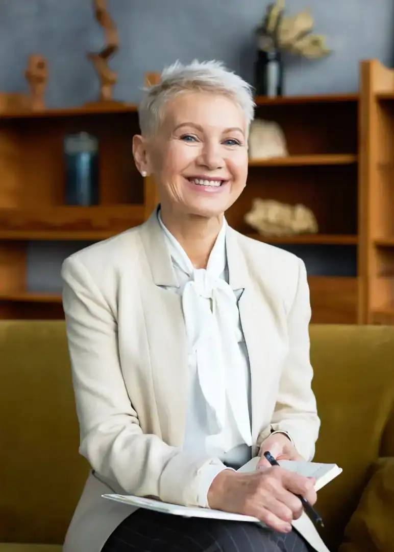 Smiling therapist holding a notebook in a mental health counseling office