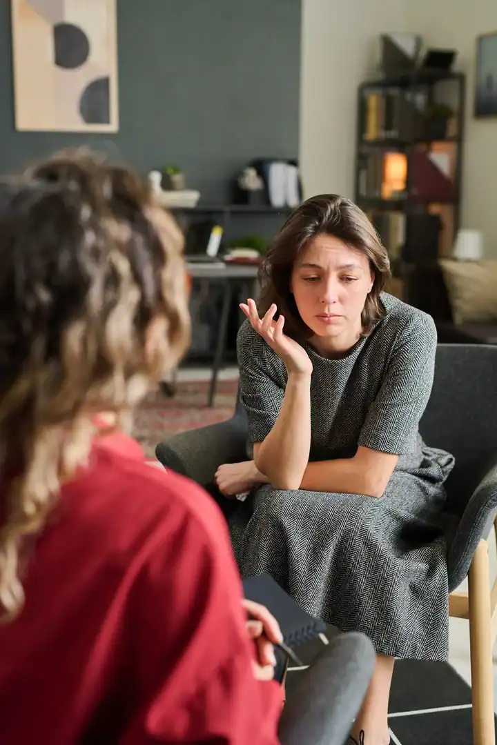 Client speaking with a therapist during a counseling session in an office