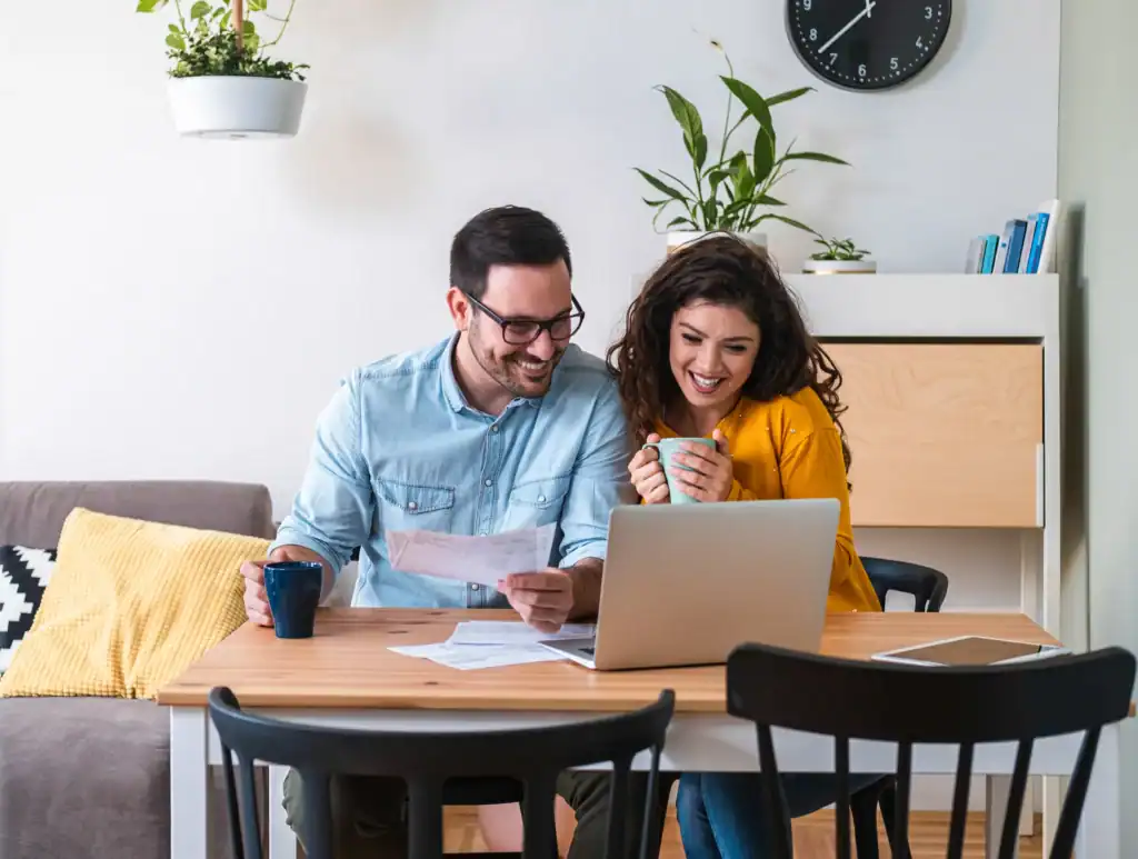 Couple sitting together at home reviewing paperwork and insurance documents on a laptop, representing the process of verifying coverage before starting IOP
