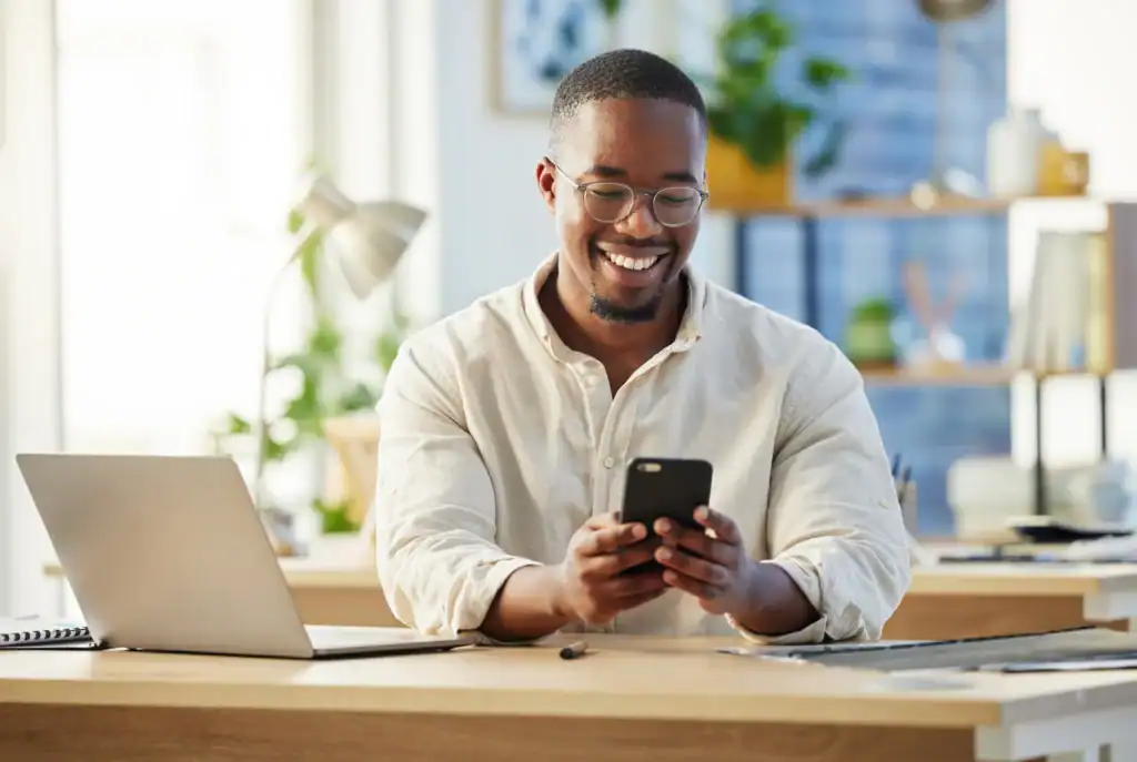 Man smiling while researching payment options for depression treatment on his phone at home
