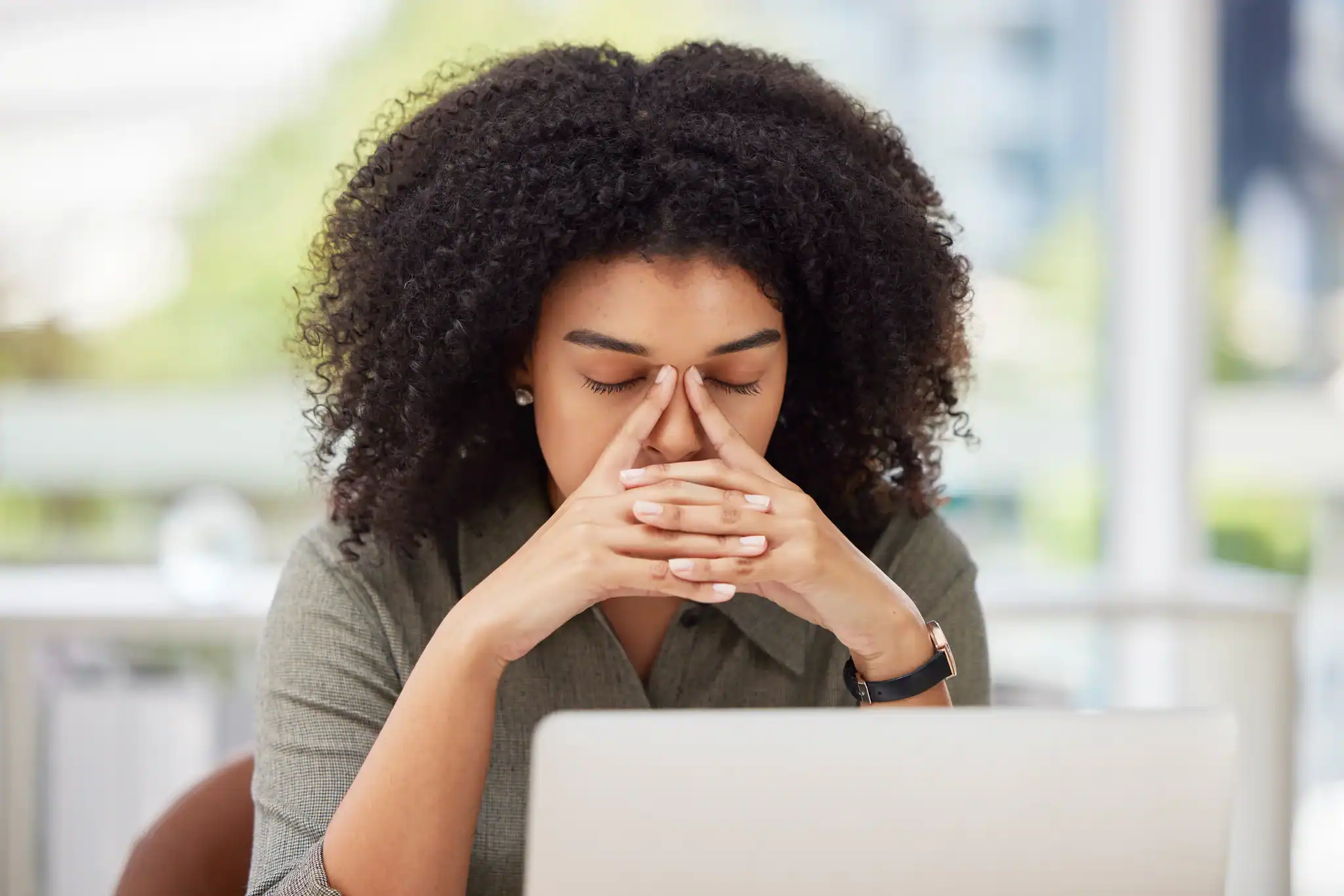 Woman experiencing burnout or depression symptoms while sitting at her desk at work