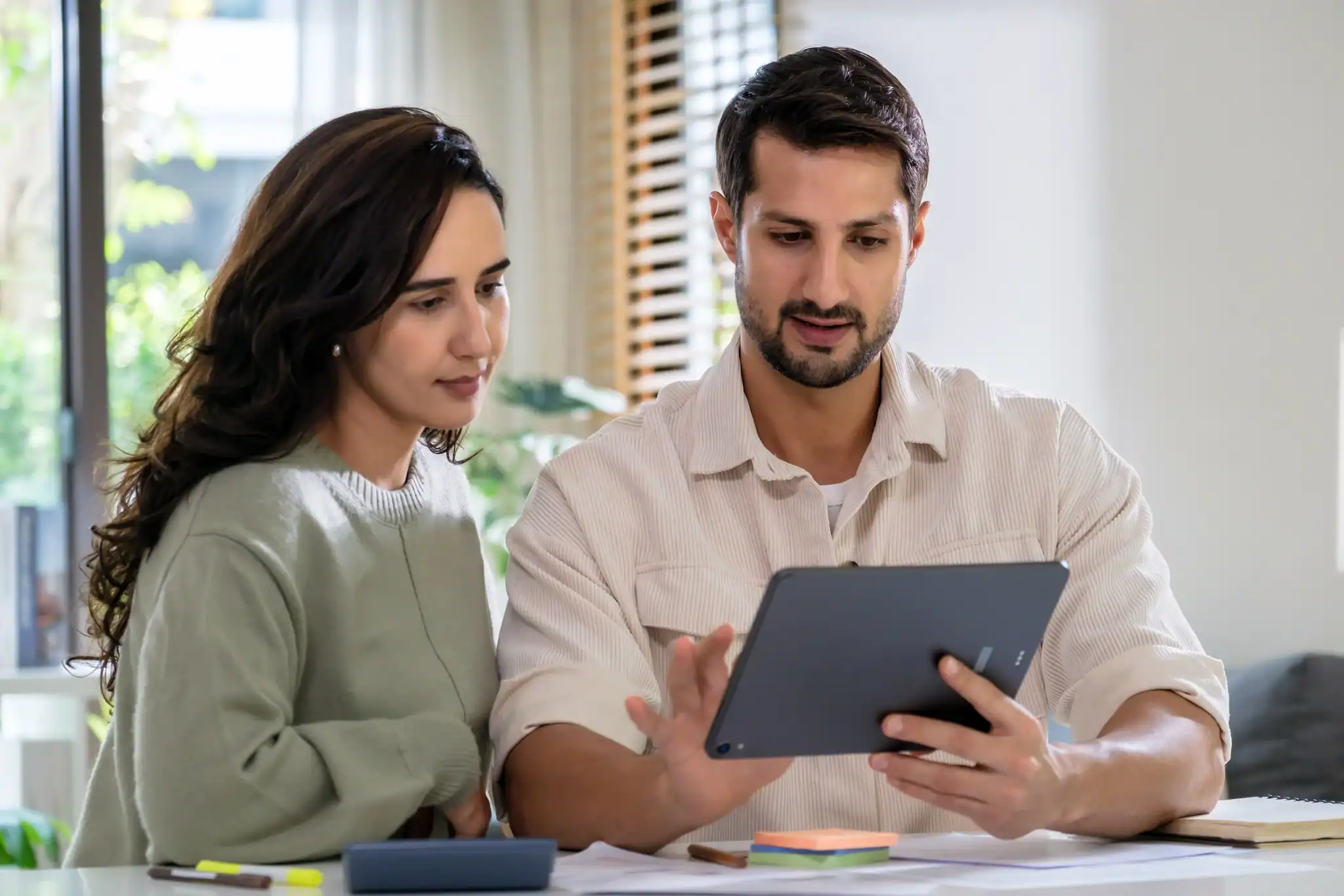 Couple at home reviewing insurance documents and calculating anxiety treatment cost.