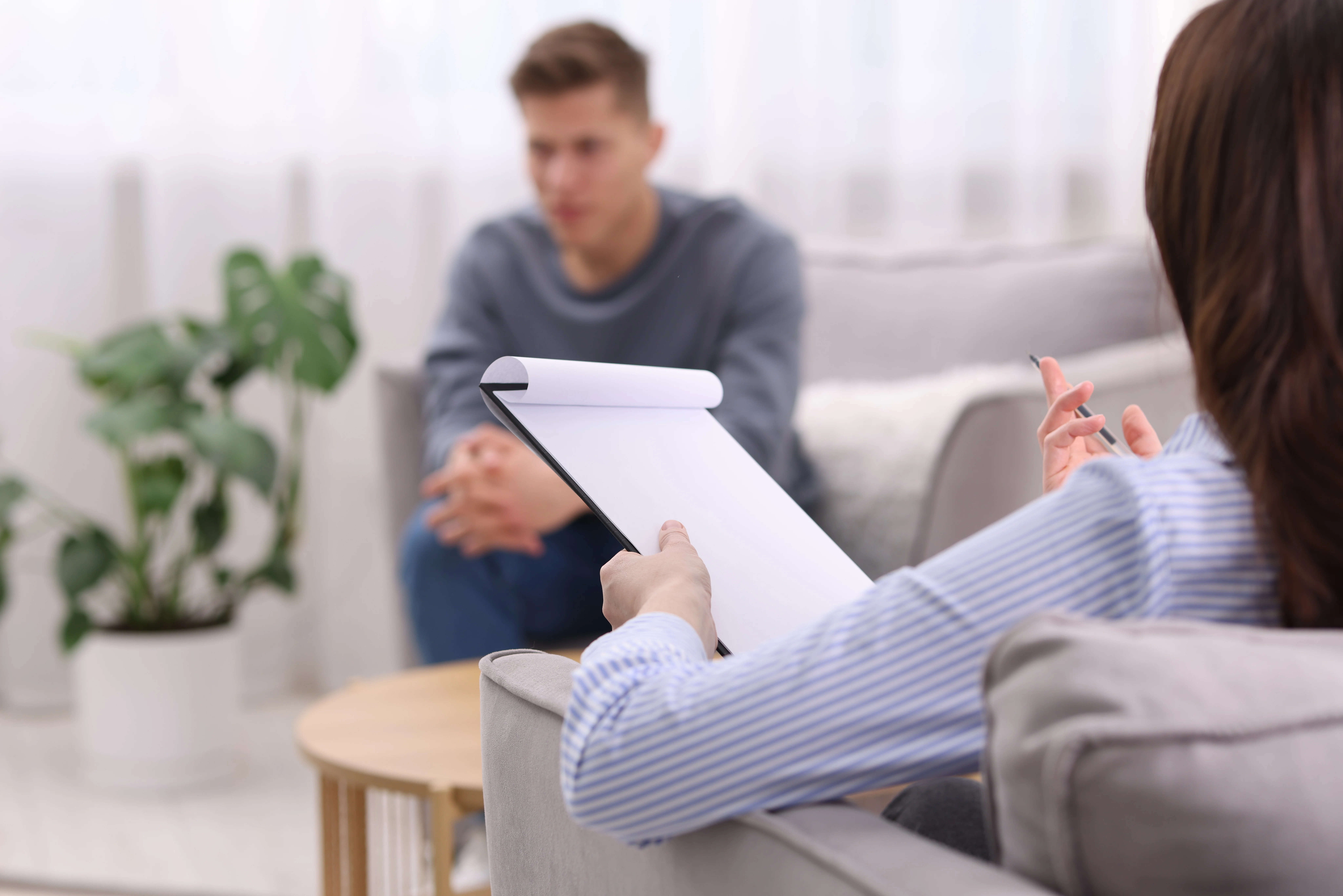 Therapist taking notes during a GAD-7 anxiety screening assessment with a client at a mental health clinic.