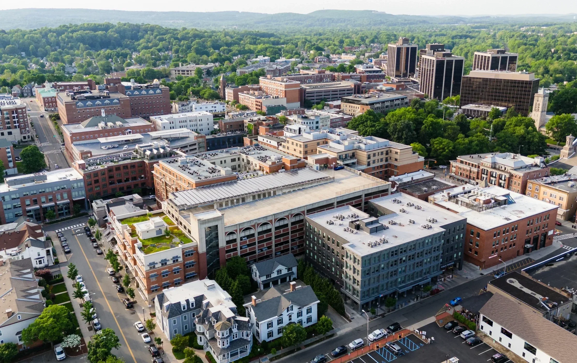 Aerial view of downtown Morristown, NJ, with office buildings, church steeples, and tree-lined streets near the Morristown Green.