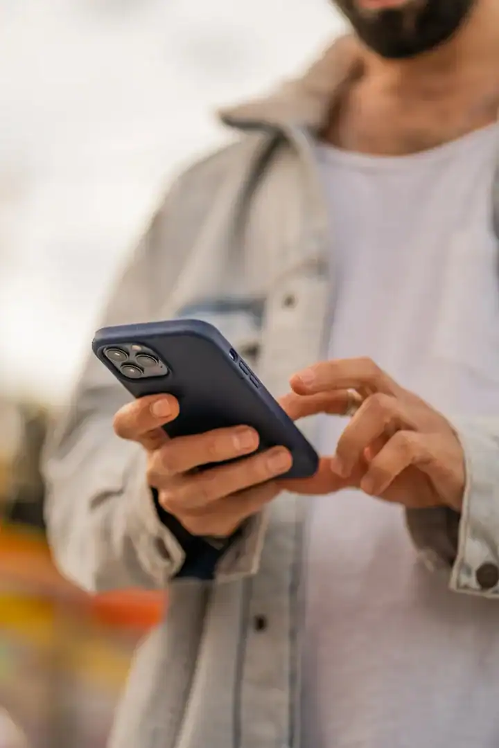 Close-up of a person's hands typing a message on a smartphone.
